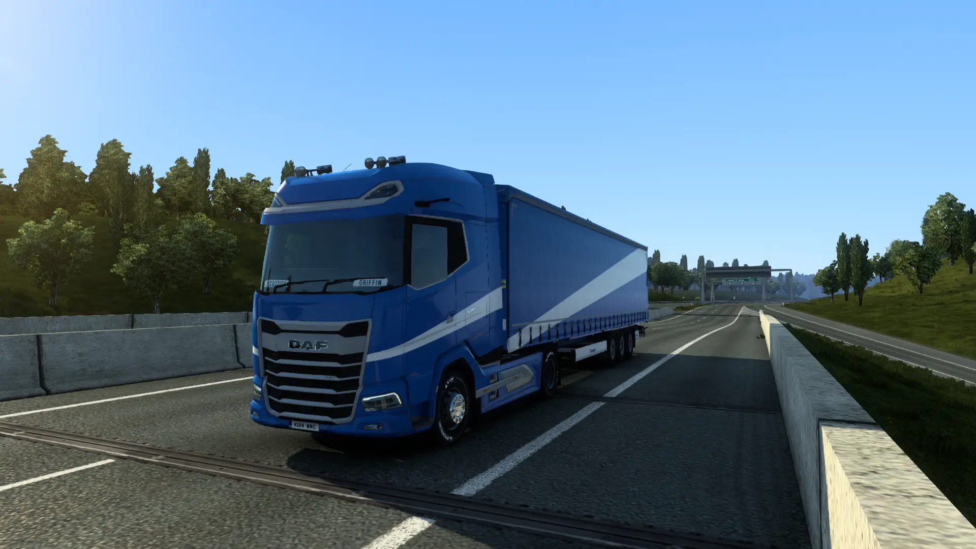 a blue daf truck driving down a highway